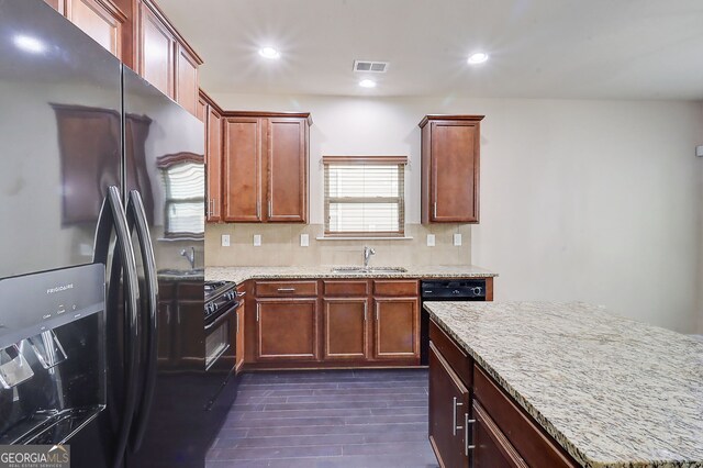 2205 Capella Cir SW, South Fulton, GA 30331 - kitchen with black refrigerator with ice dispenser, visible vents, light stone countertops, and decorative backsplash