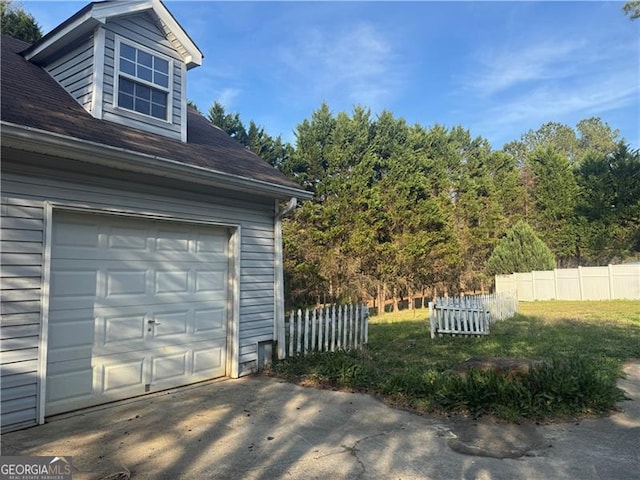 garage with driveway and fence