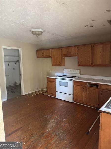 kitchen with dark wood-type flooring, light countertops, brown cabinetry, and electric range