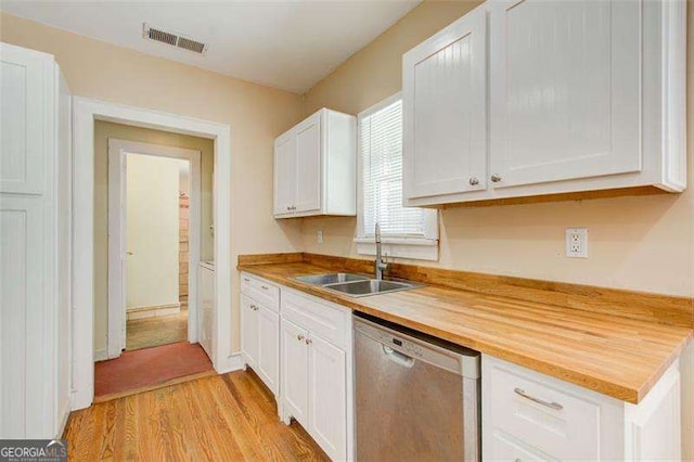 kitchen featuring a sink, white cabinetry, stainless steel dishwasher, visible vents, and light wood-style floors