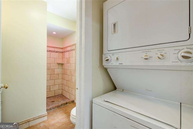 washroom with stacked washer and dryer and laundry area