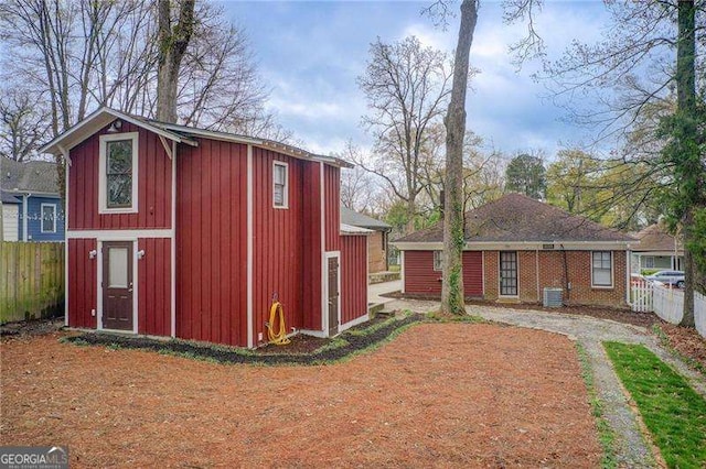 view of outbuilding with an outbuilding, central AC, and fence