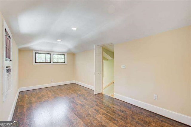 spare room with wood-type flooring, baseboards, vaulted ceiling, and recessed lighting