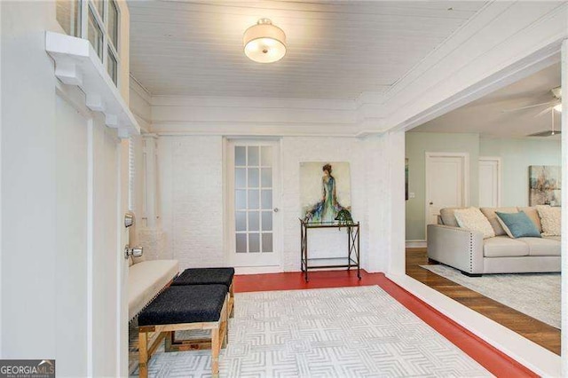 sitting room with ornamental molding and wood finished floors