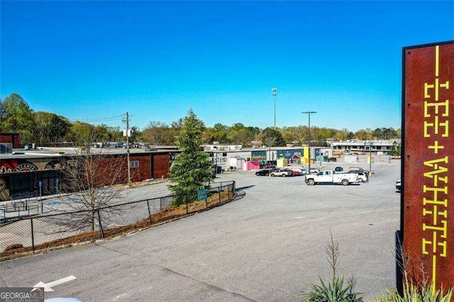 uncovered parking lot featuring fence