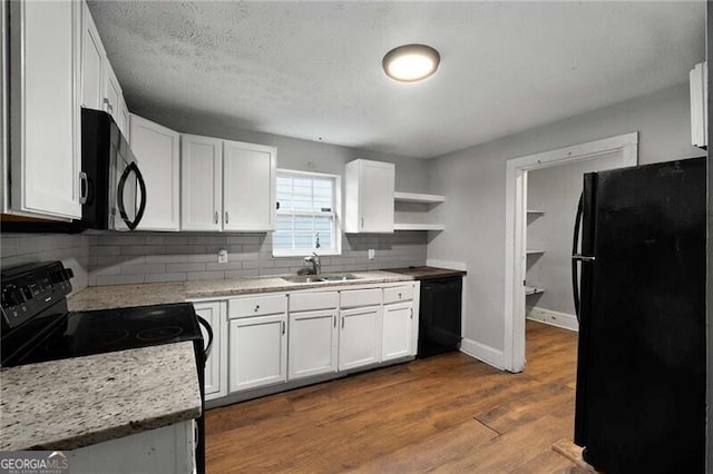1090 Harwell St NW, Atlanta, GA 30314 - kitchen featuring dark wood finished floors, white cabinetry, a sink, open shelves, and black appliances