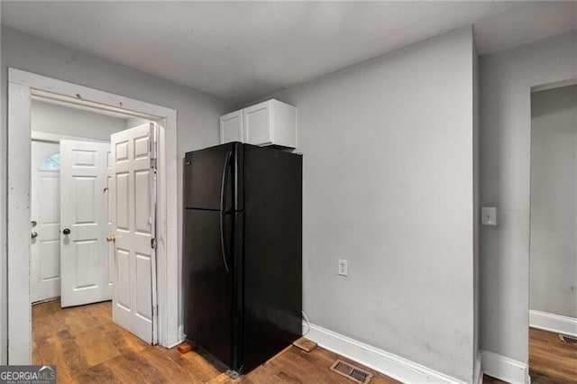 1090 Harwell St NW, Atlanta, GA 30314 - kitchen featuring visible vents, white cabinets, wood finished floors, and freestanding refrigerator
