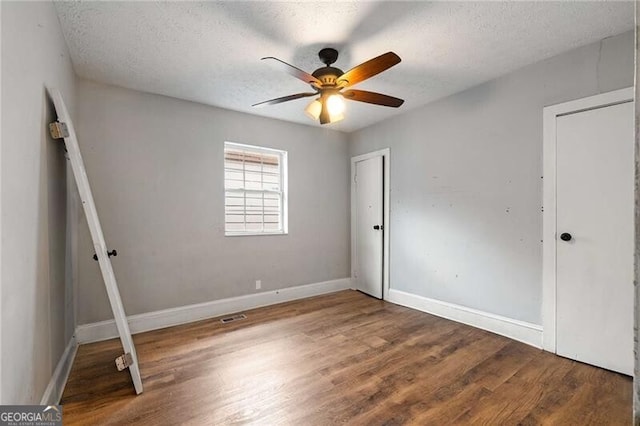1090 Harwell St NW, Atlanta, GA 30314 - unfurnished bedroom featuring baseboards, visible vents, a textured ceiling, and wood finished floors