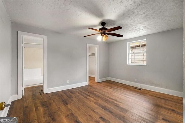 1090 Harwell St NW, Atlanta, GA 30314 - unfurnished bedroom featuring baseboards, visible vents, a spacious closet, and wood finished floors