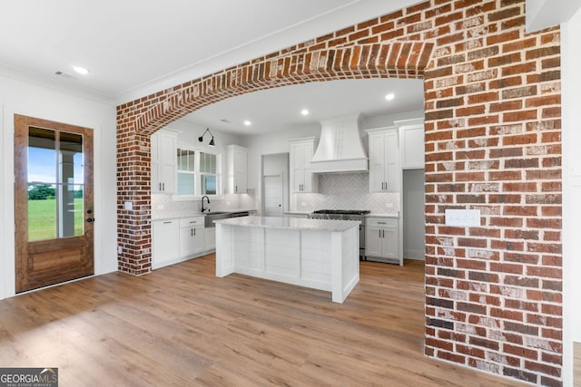 284 Community House Rd, Barnesville, GA 30204 - kitchen with custom exhaust hood, stainless steel stove, backsplash, light wood-style flooring, and plenty of natural light