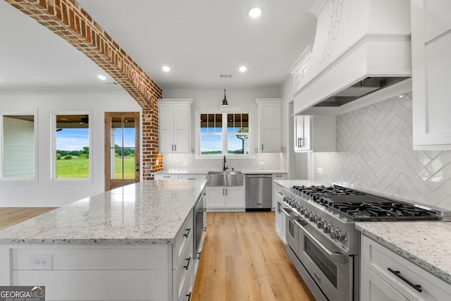 284 Community House Rd, Barnesville, GA 30204 - kitchen with stainless steel appliances, premium range hood, white cabinets, backsplash, and a kitchen island