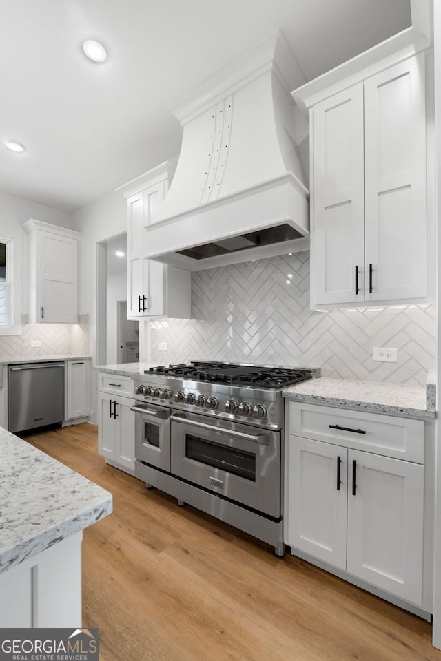 284 Community House Rd, Barnesville, GA 30204 - kitchen with stainless steel appliances, custom range hood, white cabinetry, decorative backsplash, and light stone countertops