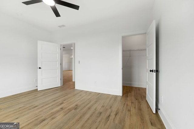 284 Community House Rd, Barnesville, GA 30204 - unfurnished bedroom featuring light wood-style flooring, a spacious closet, a closet, and ceiling fan