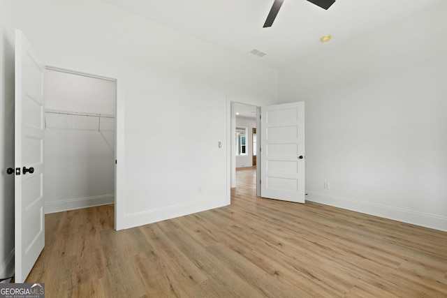 284 Community House Rd, Barnesville, GA 30204 - unfurnished bedroom with light wood-style flooring, a spacious closet, a closet, and ceiling fan