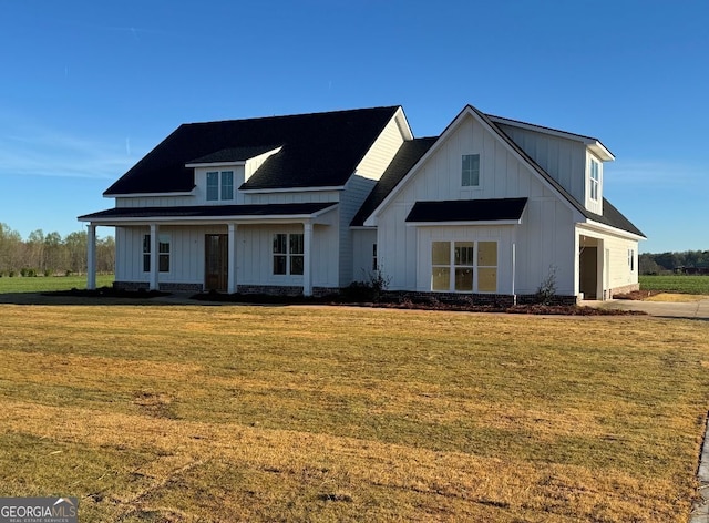 modern farmhouse style home featuring a garage, a front lawn, board and batten siding, and driveway