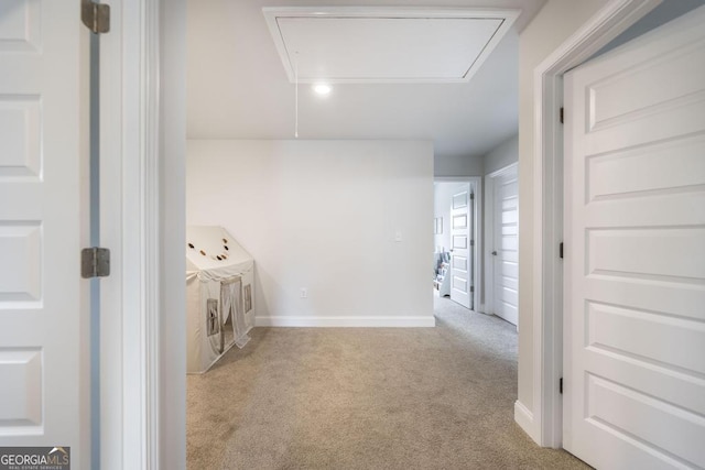corridor featuring carpet floors, baseboards, and attic access