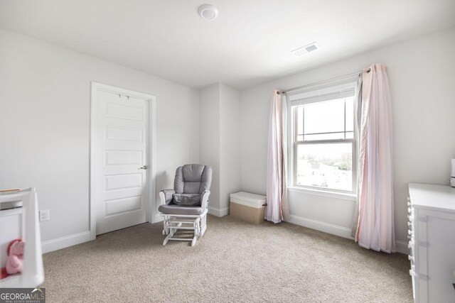 sitting room with light carpet, visible vents, and baseboards