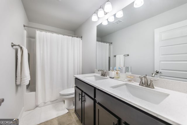 full bathroom featuring a sink, toilet, double vanity, and tile patterned flooring