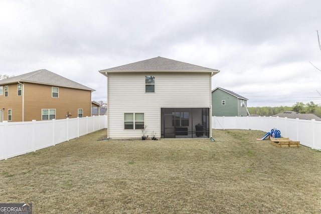 rear view of property with a sunroom, a yard, and a fenced backyard