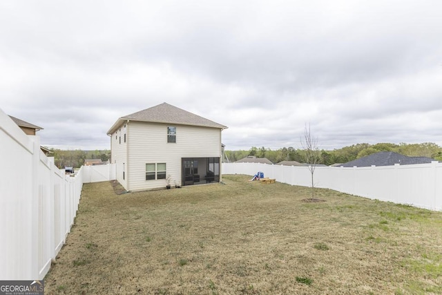 back of house featuring a fenced backyard and a lawn