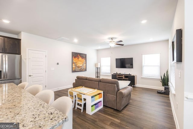 living area featuring ceiling fan, baseboards, dark wood-style floors, and visible vents