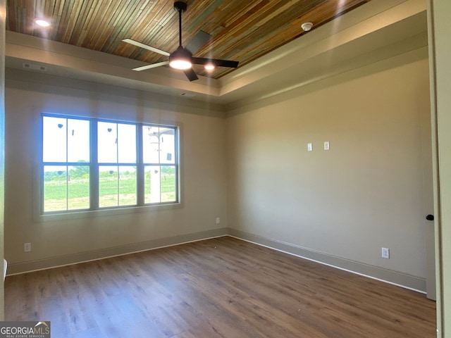 spare room featuring ceiling fan, baseboards, and wood finished floors