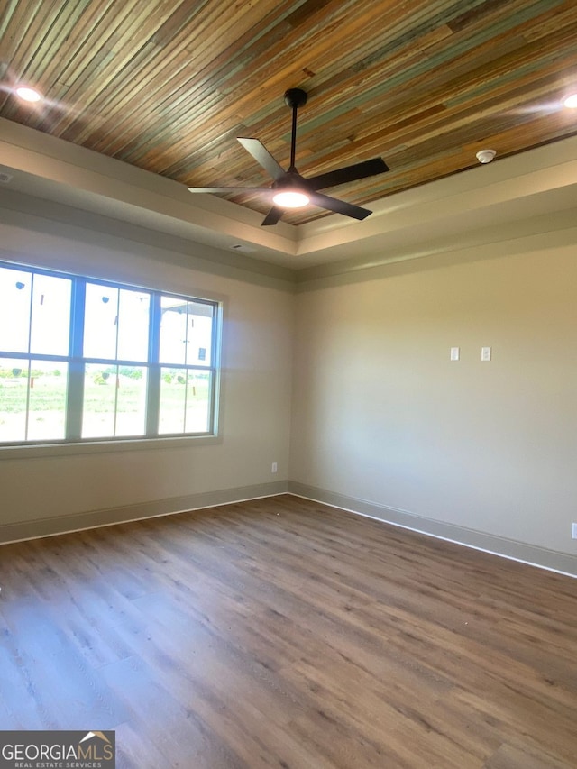 spare room with baseboards, a ceiling fan, and wood finished floors