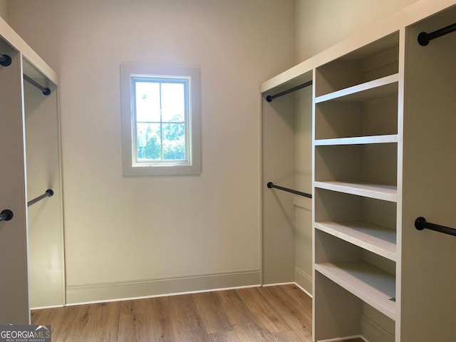 walk in closet with wood finished floors