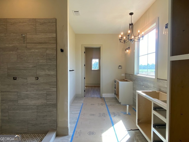 bathroom with visible vents, baseboards, and a chandelier