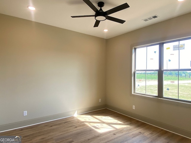 empty room with visible vents, wood finished floors, baseboards, ceiling fan, and recessed lighting