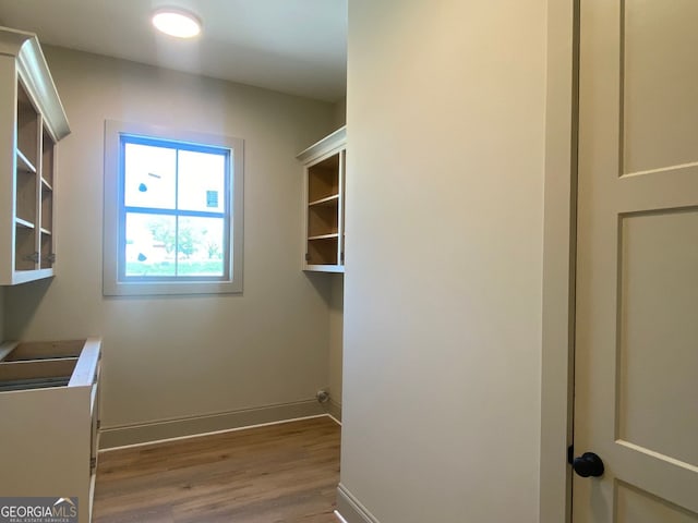 interior space featuring baseboards, laundry area, and wood finished floors