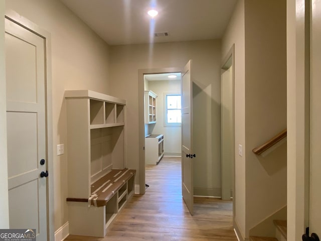 mudroom featuring baseboards, visible vents, and light wood-style floors