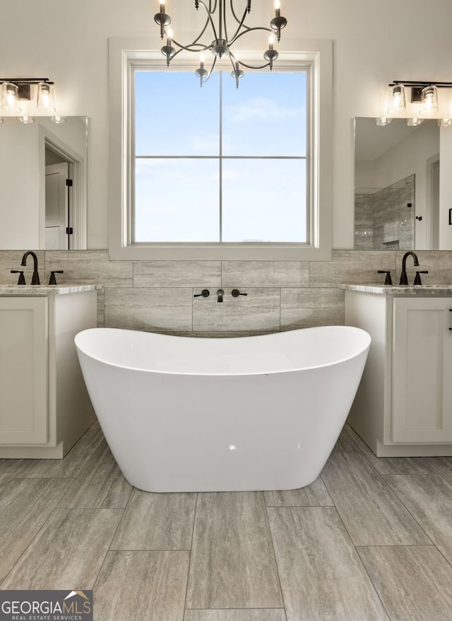272 Community House Rd, Barnesville, GA 30204 - full bathroom featuring tile walls, two vanities, a freestanding tub, a chandelier, and wainscoting