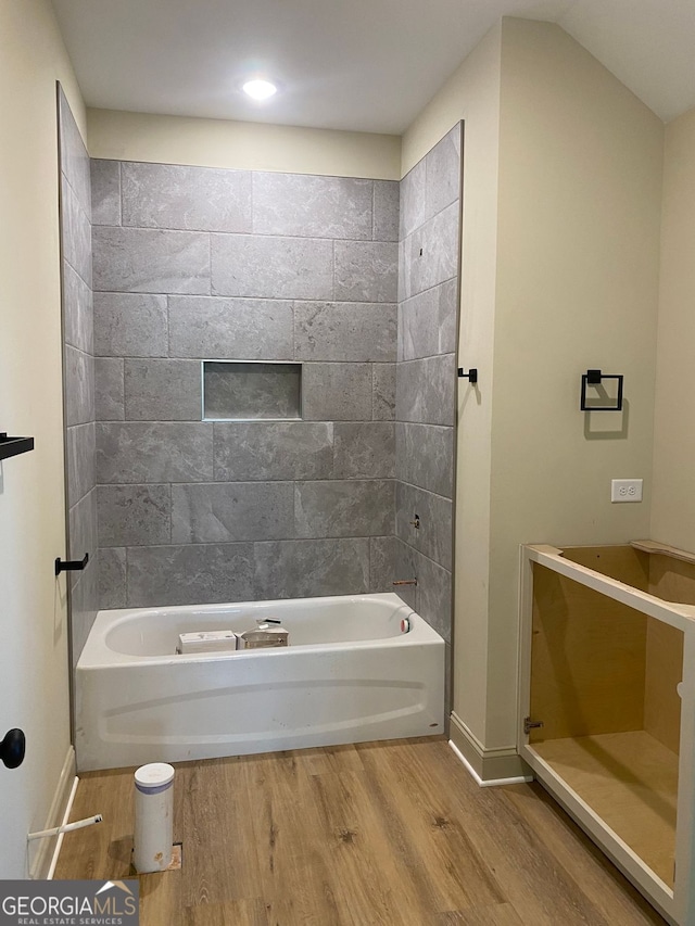 bathroom featuring baseboards, shower / bathtub combination, and wood finished floors