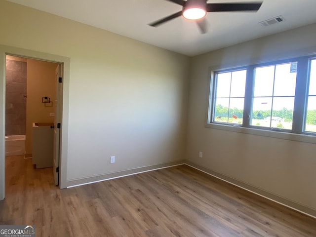 spare room with visible vents, a ceiling fan, light wood finished floors, and baseboards