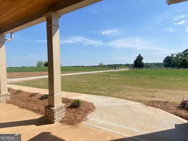 view of patio / terrace featuring fence and a rural view