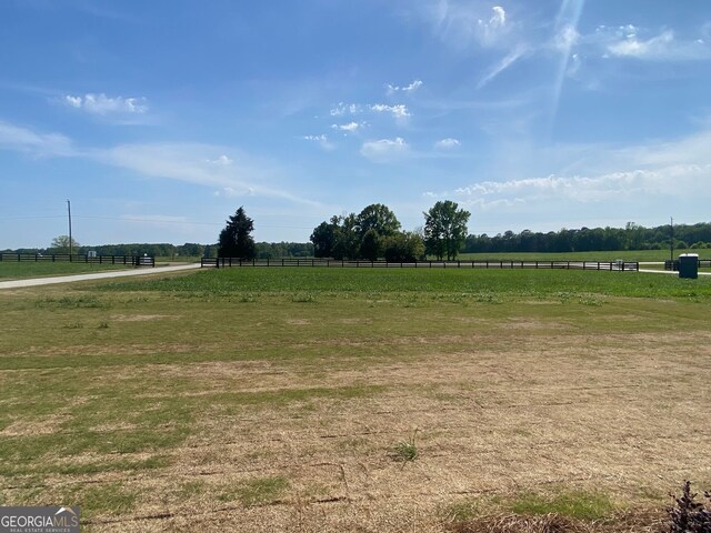 view of yard with fence and a rural view