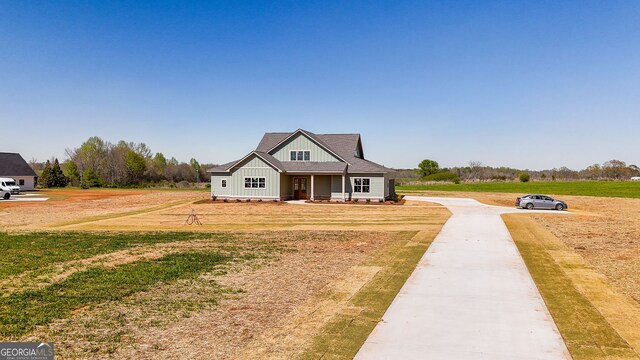 craftsman house featuring a front lawn, board and batten siding, and concrete driveway