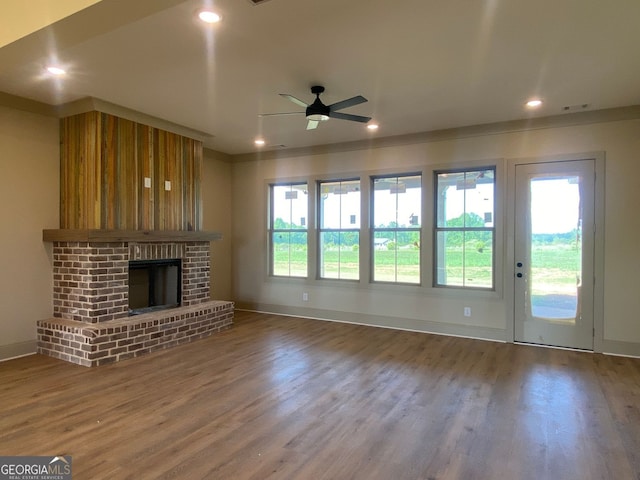 unfurnished living room with wood finished floors, a fireplace, baseboards, ceiling fan, and recessed lighting