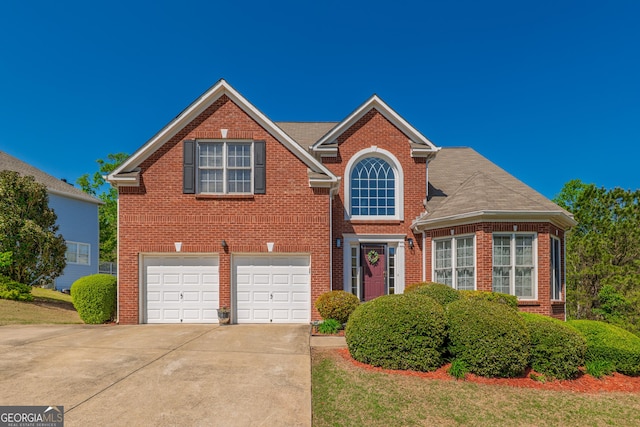 traditional-style house with brick siding, a garage, and concrete driveway