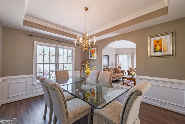 dining space with a raised ceiling, plenty of natural light, and arched walkways