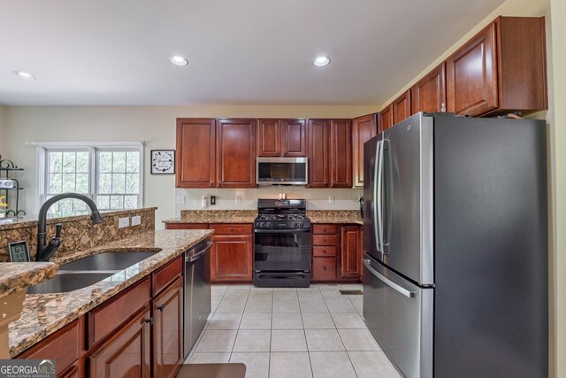 kitchen featuring appliances with stainless steel finishes, a sink, light tile patterned floors, light stone counters, and recessed lighting