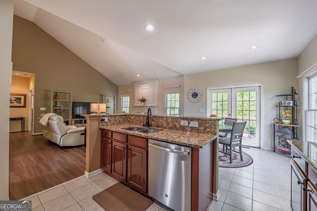 kitchen with plenty of natural light, dishwasher, a sink, light tile patterned floors, and open floor plan