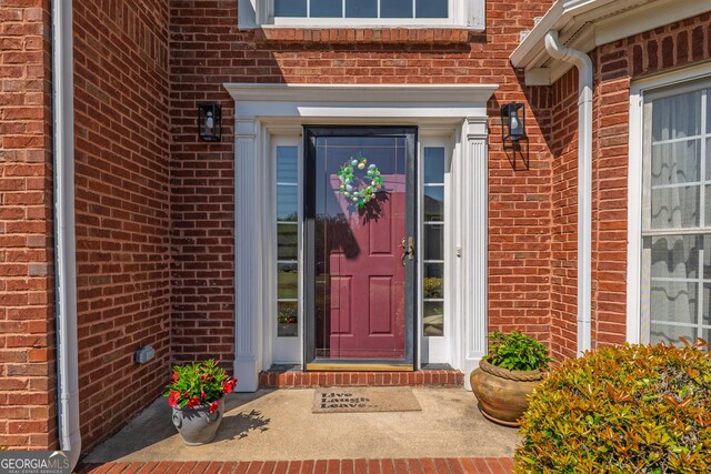 entrance to property featuring brick siding