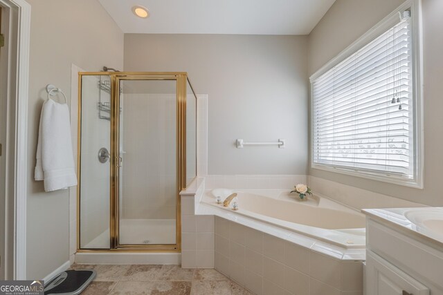 full bath with vanity, a bath, and a shower stall
