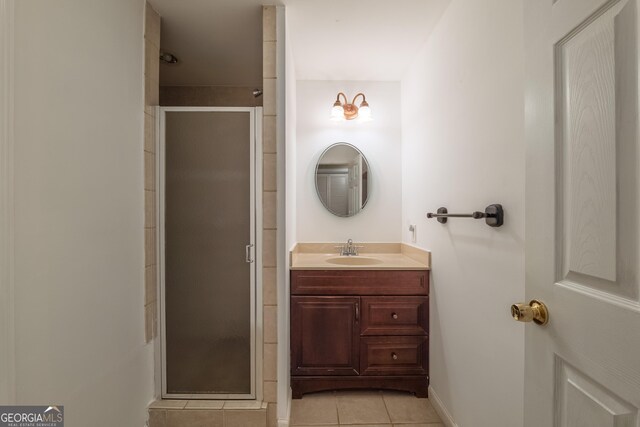 full bath featuring vanity, baseboards, tile patterned flooring, and a stall shower