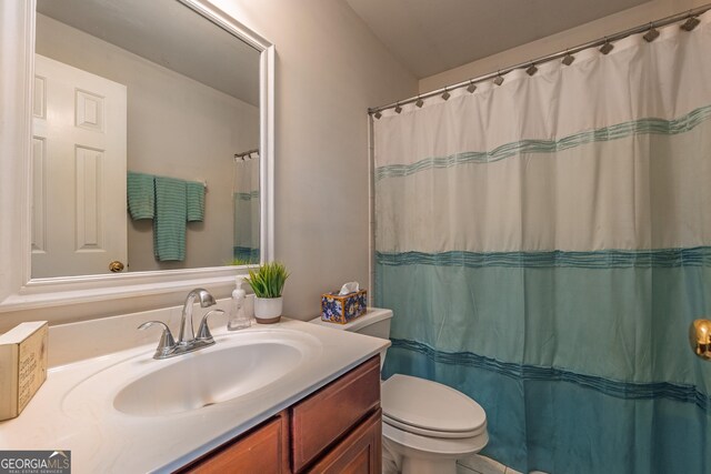 bathroom featuring toilet, curtained shower, and vanity