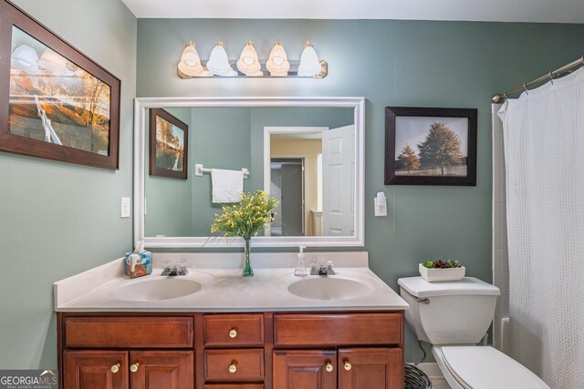 bathroom with double vanity, a sink, curtained shower, and toilet