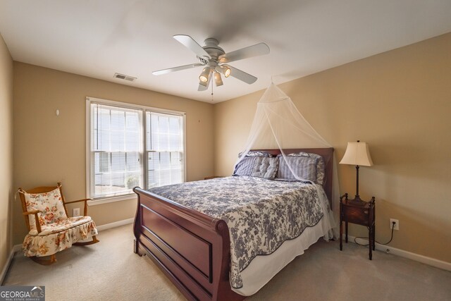 bedroom with visible vents, baseboards, ceiling fan, and light carpet