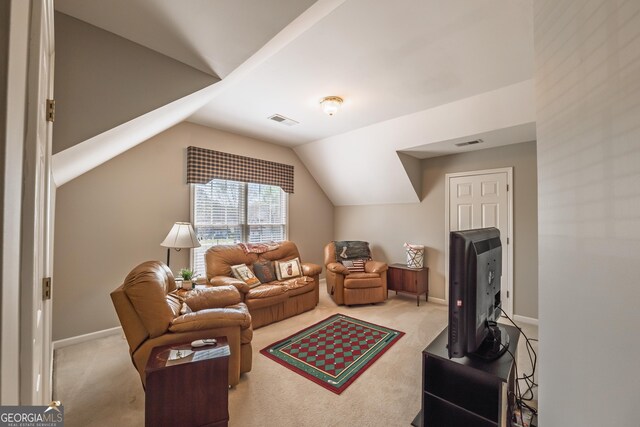 carpeted living room featuring visible vents, baseboards, and vaulted ceiling
